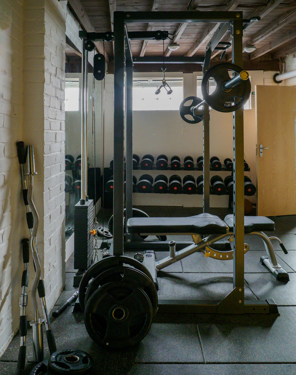 Complete home gym met dumbbells, halterstang, halterschijven, kettlebells, trainingsbank en power rack