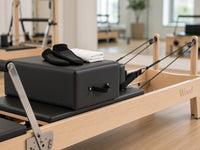 Detail van de Wood Reformer The Maple Studio Black Edition: esdoornhouten frame met Wood-logo, zwarte zitbox en touwen