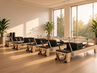Pilatesstudio ingericht met meerdere Wood Reformer The Maple Studio Black Edition reformers van esdoornhout met zwarte bekleding