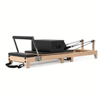 Wood Reformer The Oak Foldable Black Edition – inklapbare pilates reformer van eikenhout met zwarte bekleding, productfoto op witte achtergrond