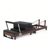 Wood Reformer The Walnut Foldable Black Edition – inklapbare pilates reformer van walnotenhout met zwarte bekleding, productfoto op witte achtergrond