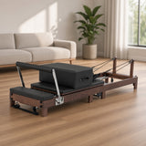 The Walnut Foldable Black Edition: walnotenhouten pilates reformer met zwarte bekleding in een lichte woonkamer, ideaal voor pilates thuis