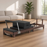 The Walnut Foldable Black Edition: walnotenhouten pilates reformer met zwarte bekleding in een lichte woonkamer, ideaal voor pilates thuis